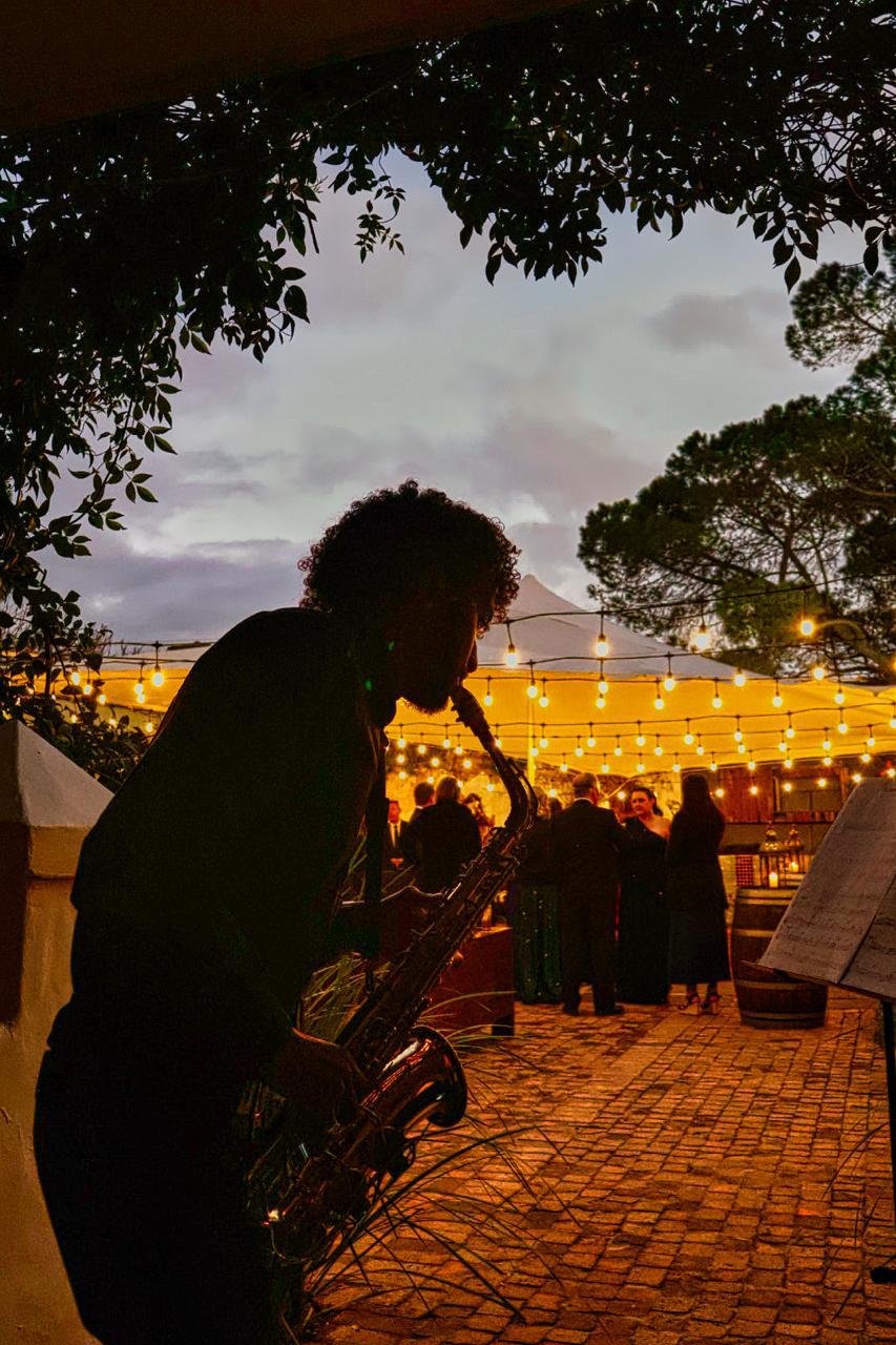 Live saxophonist entertaining wedding guests outdoors